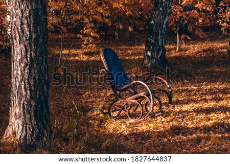 Rocking chair in the autumn garden. Autumn mood.