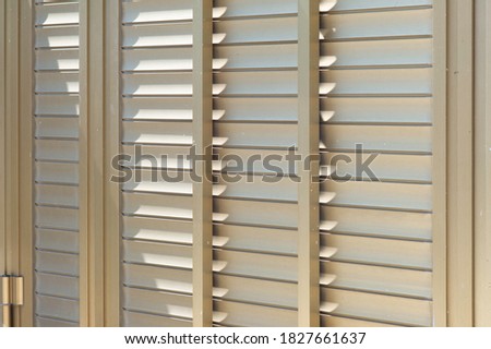 Closed gold-colored metallic shutters, metal blinds with hinge Royalty-Free Stock Photo #1827661637