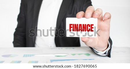 businessman holding a card with text FINANCE