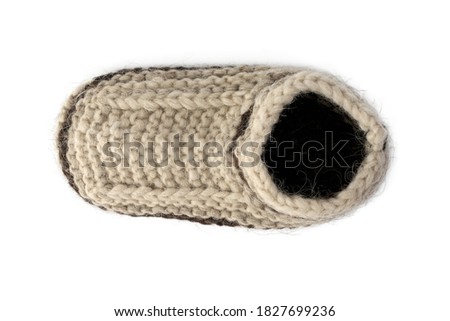 Warm knitted socks from sheepskin wool isolated on white background. Large knitting, handmade, tied by hands. For cold climates, traditional wool socks. Brown beige color, keep their shape.