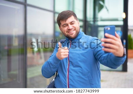 Bearded tourist man with backpack enjoy the beautiful view of the modern city, beautiful bearded man selfie in the city