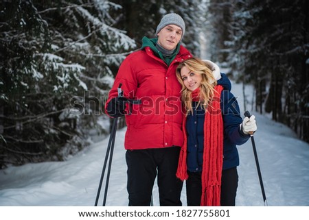 A young couple got out of the city into the woods to go skiing.