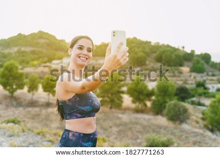 Young woman standing with her photo taken before she started running. Healthy living, running in the mountains.