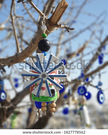 Toy windmill hanging from the tree.