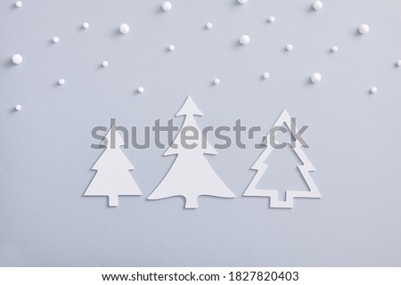 Christmas minimal concept - monochrome layout with white fir tree and snowfall. Horizontal composition, flat lay, top view. White fir tree silhouette. Merry christmas background. New year christmas.