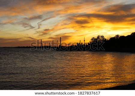 Sunset in city Toronto. Blue and yellow colors cloudy sky and lake
