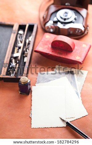 retro photos , vintage ink , pen, blotter and camera on old leather table