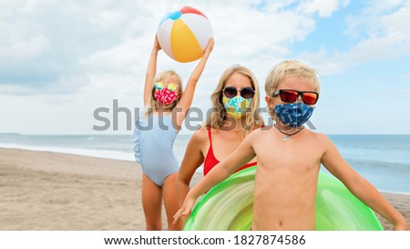 Funny children in sunglasses, inflatable toys on tropical sea beach. New rules to wear cloth face covering mask at public places due coronavirus COVID 19. Family holidays with children, summer travel