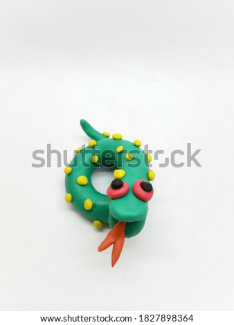Front view of Plasticine statue A green snack with Yellow pattern on a white background.