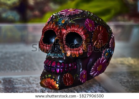 Mexican day of the dead skull with multicolored daisies and purple teeth