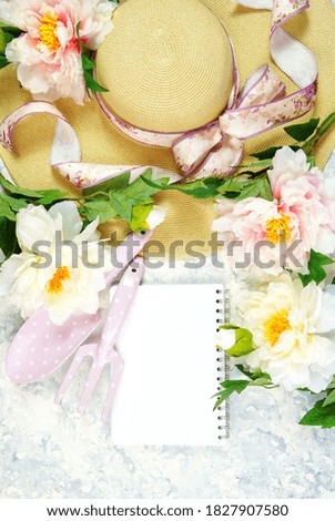 Spring theme, peonies and sunhat desktop workspace with potepad on stylish white marble textured background. Top view blog hero header creative composition flat lay.