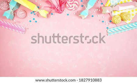 Happy birthday party pastel colors theme modern creative layout flat lay with decorations, party hats and food on pink textured background with decorated borders and negative copy space.