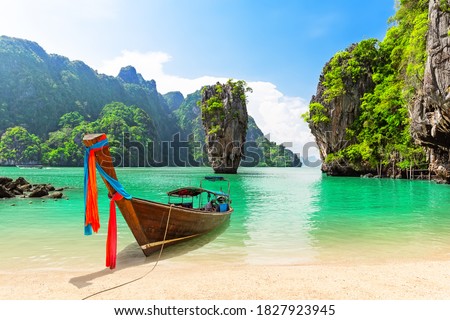 Famous James Bond island near Phuket in Thailand. Travel photo of James Bond island with thai traditional wooden longtail boat and beautiful sand beach in Phang Nga bay, Thailand. Royalty-Free Stock Photo #1827923945