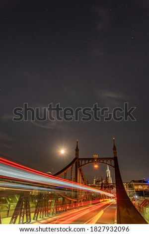 Long exposure shot of the full moon sky over the "Neutorbrücke" steel bridge, with vehicle light trails