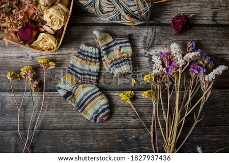 Colorful woolen baby socks, vintage scene on dark background