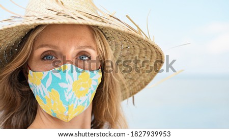 Funny portrait of young woman in straw hat on tropical sea beach. New rules to wear cloth face covering mask at public places due coronavirus COVID 19. Family holiday with kids, travel at summer 2020.