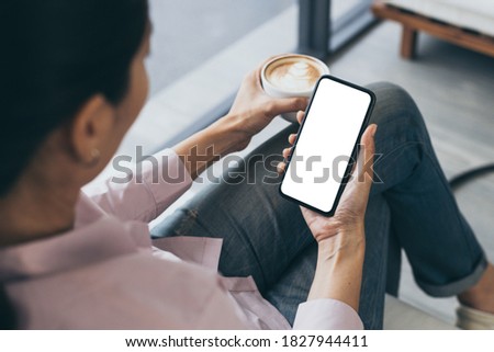 cell phone mockup blank white screen.woman hand holding texting using mobile on desk at coffee shop.background empty space for advertise.work people contact marketing business,technology