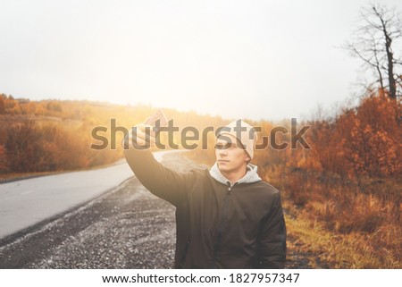 Young man taking selfie in autumn