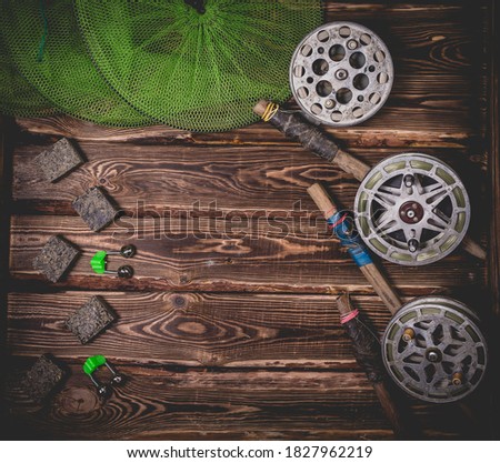 Old rarity bottom fishing reels on a wooden background. Bell, fish tank and makuha cubes. Studio photo with place for text