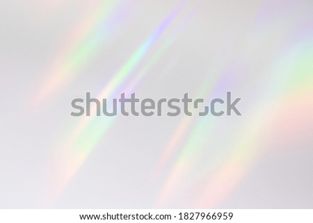 Blurred rainbow light refraction texture overlay effect for photo and mockups. Organic drop diagonal holographic flare on a white wall. Shadows for natural light effects Royalty-Free Stock Photo #1827966959