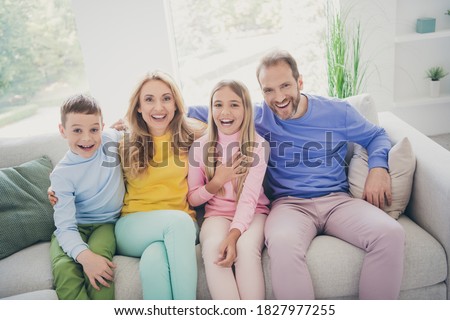Photo of dream comfort family sit couch mom dad two kids boy girl watch tv laughing in house indoors
