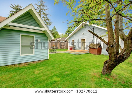 House with backyard deck and small patio area. View of tree and bird feeder