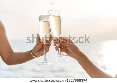 Hand holding a glass drinking wine on Sunset sea background. Royalty-Free Stock Photo #1827988394