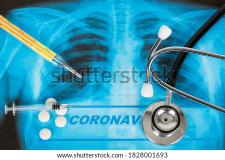 Novel Covid-19, Wuhan virus concept from China. Text phrase Coronavirus on lungs radiology blue image background, with stethoscope, pills, tablets, syringue vaccine and thermometer