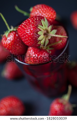 Studio photo of many strawberries on a dark textured surface. Selective focus, shallow depth of field.
