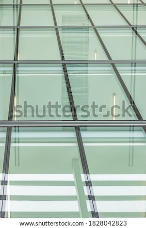 Minimalistic glass facade, ultra-slim steel framework holding the large transparent panels. Contemporary architecture, corporate office design, vertical converging geometric lines. Neutral white light