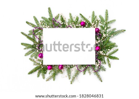 Christmas frame from a Christmas tree garland with decorations in pink tones. Christmas background with sheet of white paper and copy space for design template or mockup.