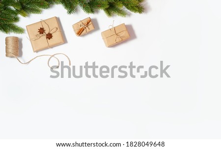 Christmas flat lay frame with copy space mockup. Present boxes and fir tree branches composition on the white paper background