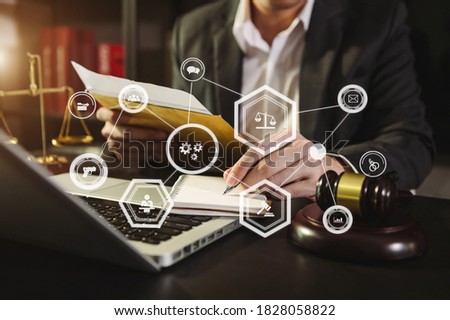 justice and law concept.Male judge in a courtroom  the gavel, working with smart phone and laptop and digital tablet computer on wood table in morning light 