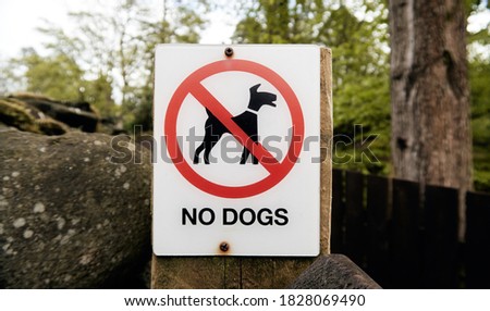 A keep out sign on a tourist countryside trail showing that dogs are banned form walking on the field and land. Dogs bans in public and private places. Dog bans across the world.