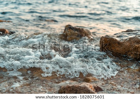 Beautiful waves hitting the rocks on the shore of a sea or ocean, photos with a short exposure