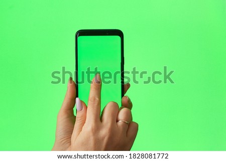 green screen phone woman using smartphone. Female hand touching, clicking, tapping, sliding, dragging and swiping on chroma key green screen background.