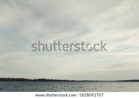 Close-up of water texture, smooth blue waves of water on the shore beach, color landscape photo of water. Landscape of air, sky, and cloud textures. Water and waves at the bottom of the frame	