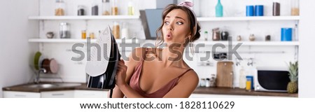 Website header of shocked housewife holding iron at home