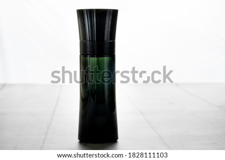 black bottle of perfume on white wooden background