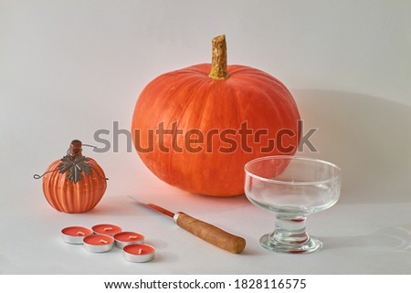 Step by step, we make a Jack Lantern head from a pumpkin. Step 1 - is to prepare all the necessary tools. pictured Pumpkin, knife, candles, glass bowl on a white background