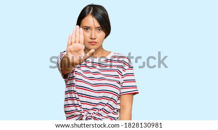 Beautiful young woman with short hair wearing casual clothes doing stop sing with palm of the hand. warning expression with negative and serious gesture on the face. 