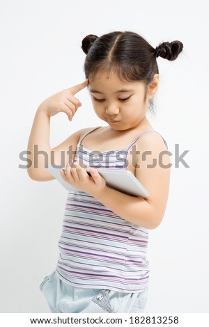Thinking Asian child with tablet computer
