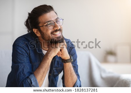 Portrait Of Smiling Indian Man With Eyeglasses And Braces In Home Interior, Handsome Pensive Western Guy Daydreaming And Looking Away, Thinking About Something, Selective Focus With Copy Space Royalty-Free Stock Photo #1828137281
