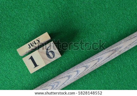 July 16, Number cube With a snooker stick on a green background, snooker table.