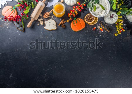 Halloween baking background with baking utensils and Halloween styled Gingerbread Cookies, black concrete background top view with copy space