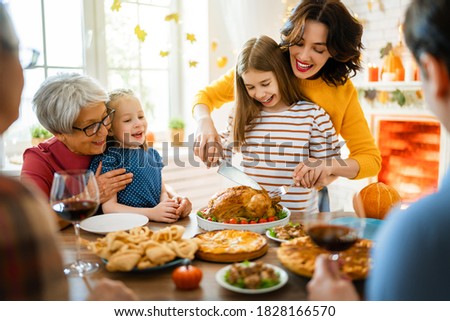 Happy Thanksgiving Day! Autumn feast. Family sitting at the table and celebrating holiday. Grandparents, mother, father and children. Traditional dinner.