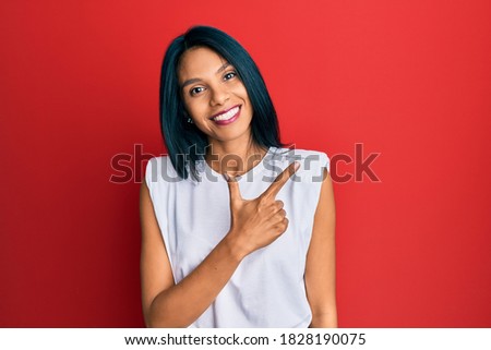 Young african american woman wearing casual clothes smiling cheerful pointing with hand and finger up to the side 
