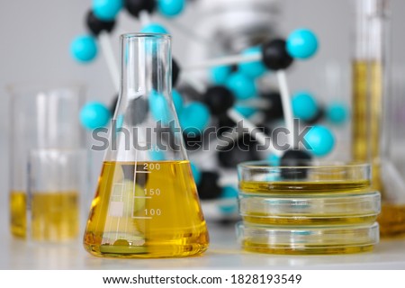 Glass test tubes with yellow viscous liquid stand on table in chemical laboratory closeup. Checking the quality of petroleum products refining concept. Royalty-Free Stock Photo #1828193549