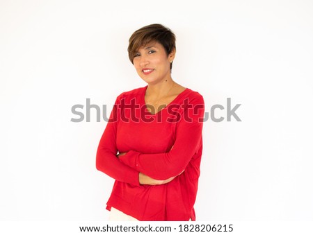 Young Colombian woman with red sweater keeping the arms crossed in frontal position