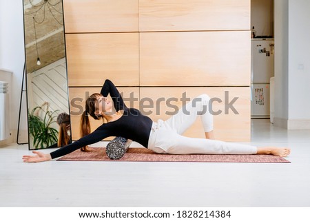 Seria photo of woman using foam roller for exercise at home. Method to release tension and help with muscle pain, a tool for exercise, physical therapy and training. Pilates,healthy lifestyle theme